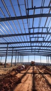 Vista longitudinal del avance de obra de una bodega prefabricada con uniones de acero empernadas