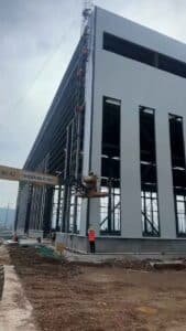 Maquinaria especializada elevando paneles de gran formato para el montaje de naves industriales