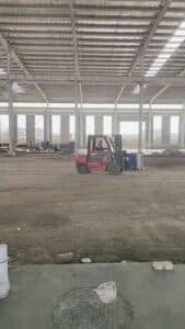 Proceso logístico de carga cuidadosa de los componentes de la estructura metálica en contenedores marítimos para su exportación a Sudamérica.