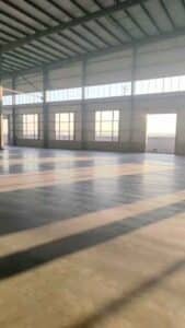 Instalación de robustas columnas de acero ancladas a cimientos de hormigón para una bodega industrial sismorresistente en Chile.