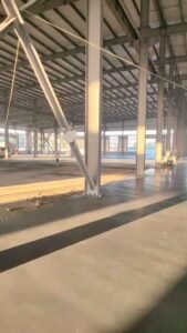 Ingenieros verificando las conexiones atornilladas de alta resistencia en los nodos principales de una bodega industrial.