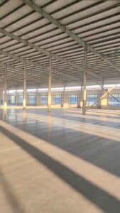 Detalle del sistema de correas de techo galvanizadas y arriostramiento estructural en el techo de una bodega industrial.