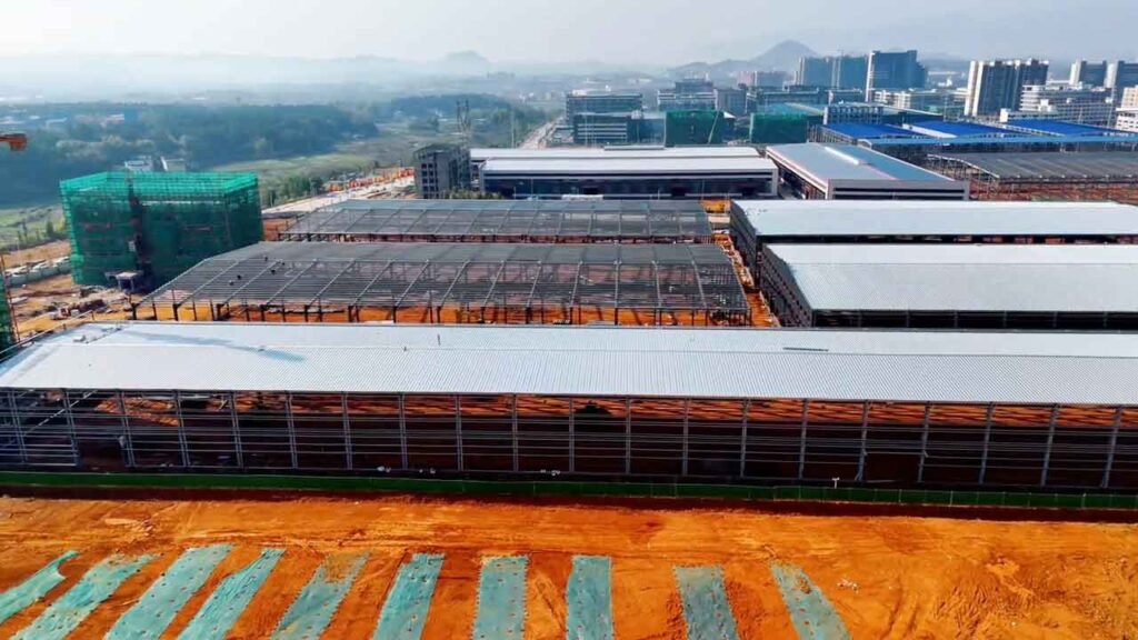 Recepción y descarga organizada de los componentes de acero en el sitio de construcción de estructuras para bodegas