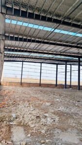 Perfilería secundaria en las paredes laterales preparada para la fijación del revestimiento en galpones prefabricados chinos.