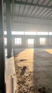 Vista exterior de una bodega industrial prefabricada en sus etapas finales de construcción, con excelentes acabados estéticos.