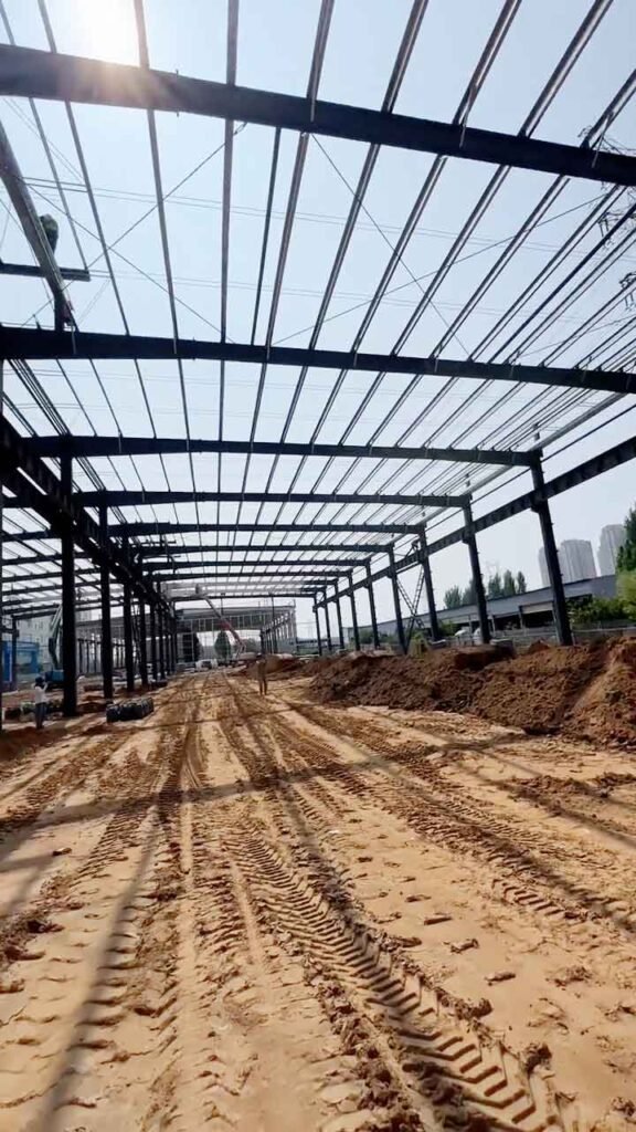 Instalación de paneles sándwich color azul y gris para aislamiento en galpón metálico prefabricado.