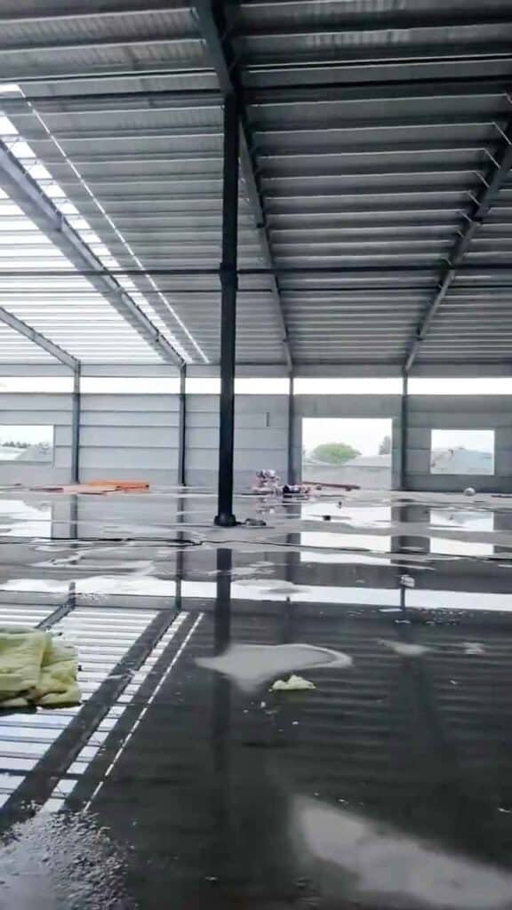 Trabajadores asegurando los perfiles laterales (girts) para el cerramiento de paredes en estructuras metálicas importación exportación