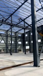 Electrical cables and clean concrete floor during the installation of an industrial steel structure warehouse.