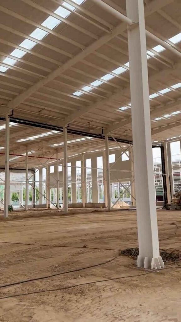 Trabajadores instalando paneles de techo para impermeabilizar galpones chinos.