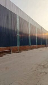 Trabajadores instalando el aislamiento y las chapas metálicas en el techo de galpones prefabricados chinos
