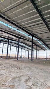 Vista interior durante la fase constructiva mostrando las conexiones atornilladas de los galpones prefabricados chinos.