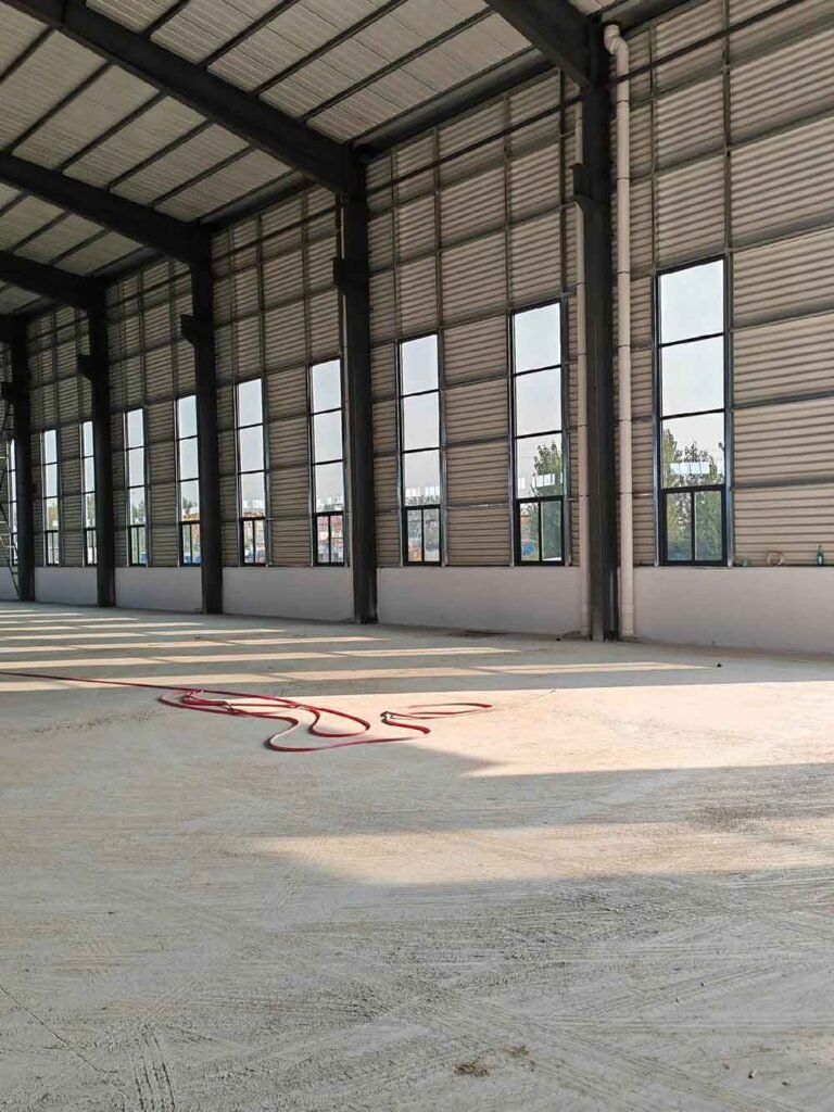 Spacious interior of a modern metal building with optimized natural lighting through vertical windows.