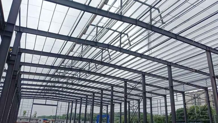 Montaje de columnas de acero con pintura anticorrosiva roja sobre pernos de anclaje en la fabricacion de galpones sismorresistentes