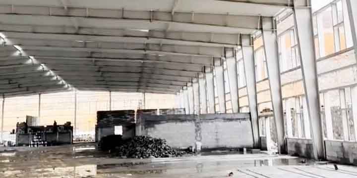 Detalle de ingeniería de la placa base gruesa y pernos de anclaje para la cimentación sólida de un galpón metálico.