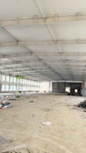 Secuencia de múltiples pórticos estructurales de acero erigidos para conformar un gran galpón metálico de almacenamiento.