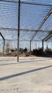 Rigid frame steel columns anchored securely to a concrete foundation for an industrial metal building.