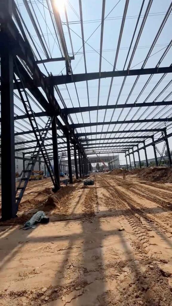 Detalle de canaletas de lluvia y tubos de bajada de agua en el exterior de un galpón metálico prefabricado