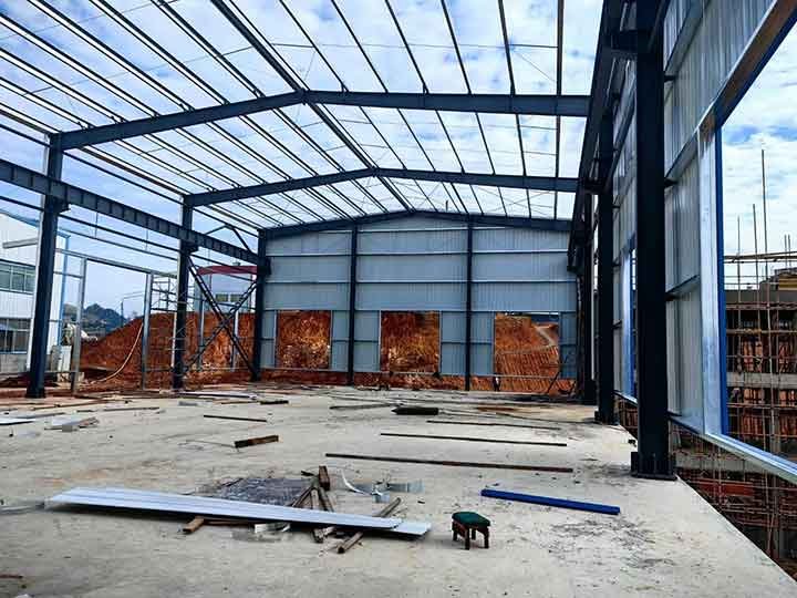 Revestimiento metálico lateral en proceso de montaje de galpones con marcos rígidos