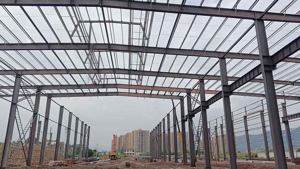 Obreros instalando chapas metálicas acanaladas en la cubierta durante la fabricacion de galpones resistentes a huracanes.