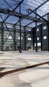 Horizontal metal purlins on the walls of a warehouse metal building prepared for insulating panel installation.