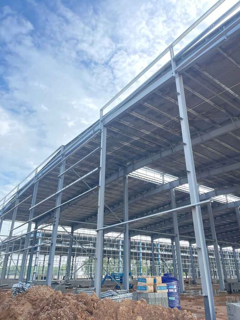 Progression of exterior corrugated wall cladding installation on a Metal Building, utilizing precision-cut materials from a reliable steel building supplier