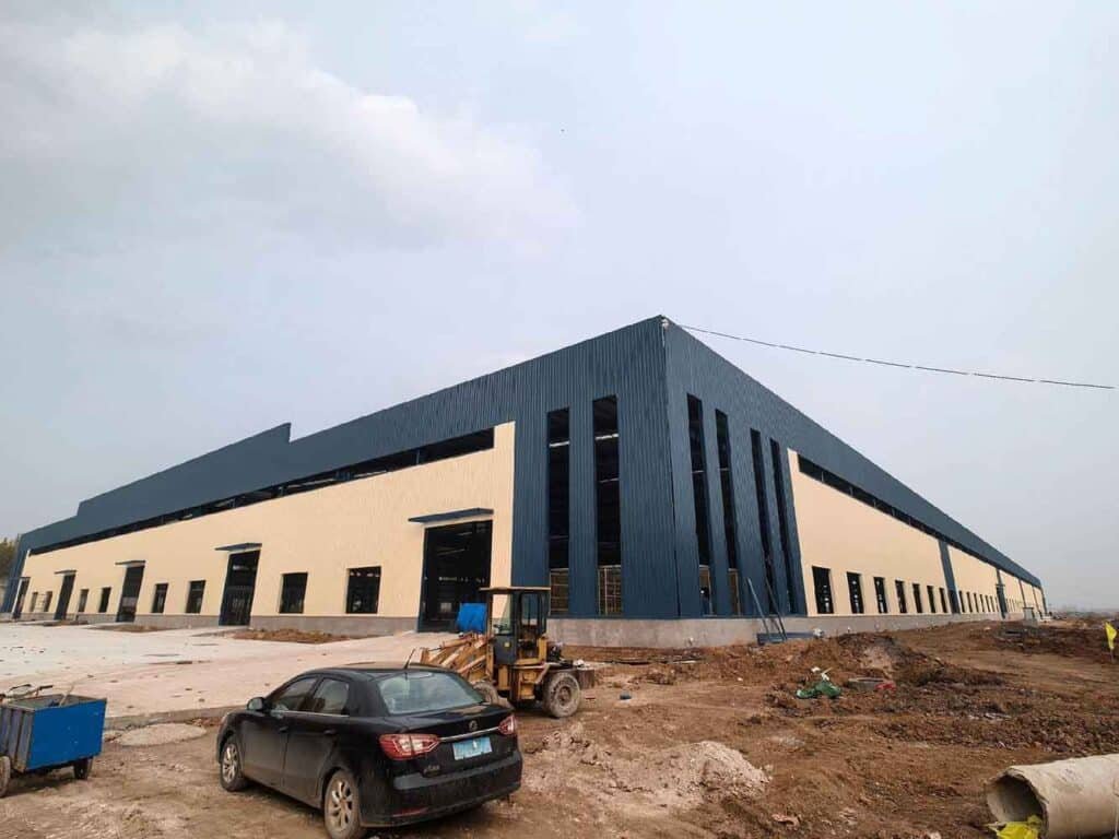 Fachada exterior con paneles metálicos azules y crema instalados por un fabricante de estructuras metálicas comerciales con cerramientos.