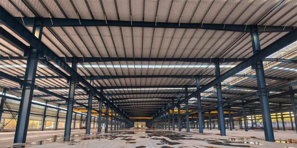 Interior diáfano de una nave con techo aislado, construida por un fabricante de estructuras metálicas industriales de gran luz.