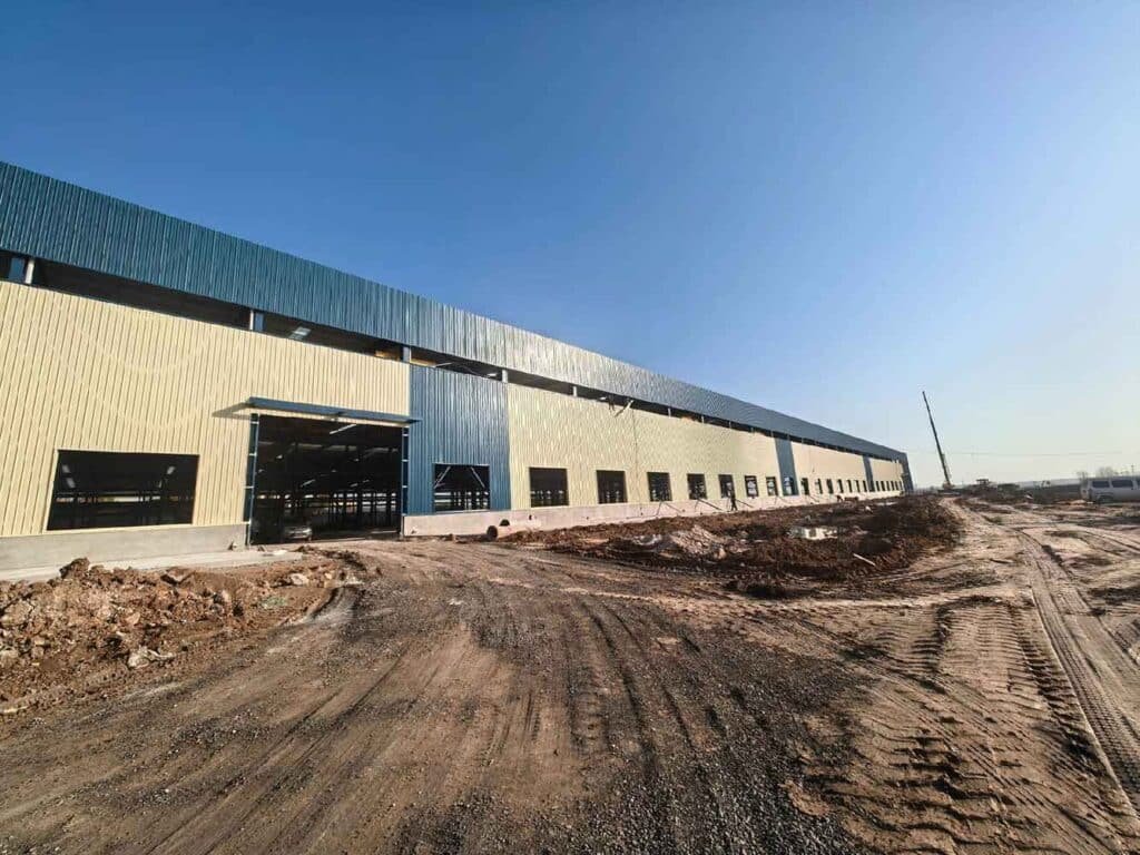 Perspectiva lateral de un extenso centro de distribución edificado por un fabricante de estructuras metálicas logísticas de gran formato.