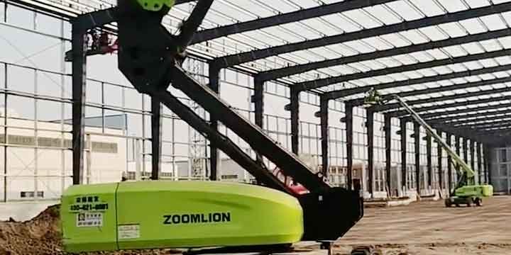 Base de un equipo de elevación verde operando frente a la extensa cuadrícula de vigas y columnas de un steel structure building en construcción.