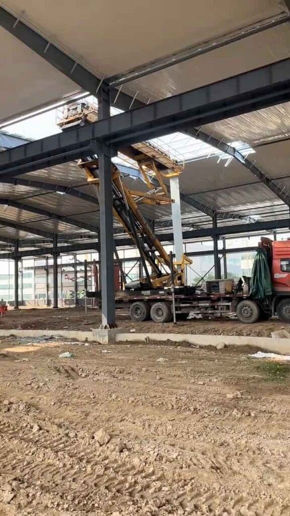 Operación de grúa elevadora dentro de un almacén industrial moderno en proceso de ensamblaje de paneles de techo