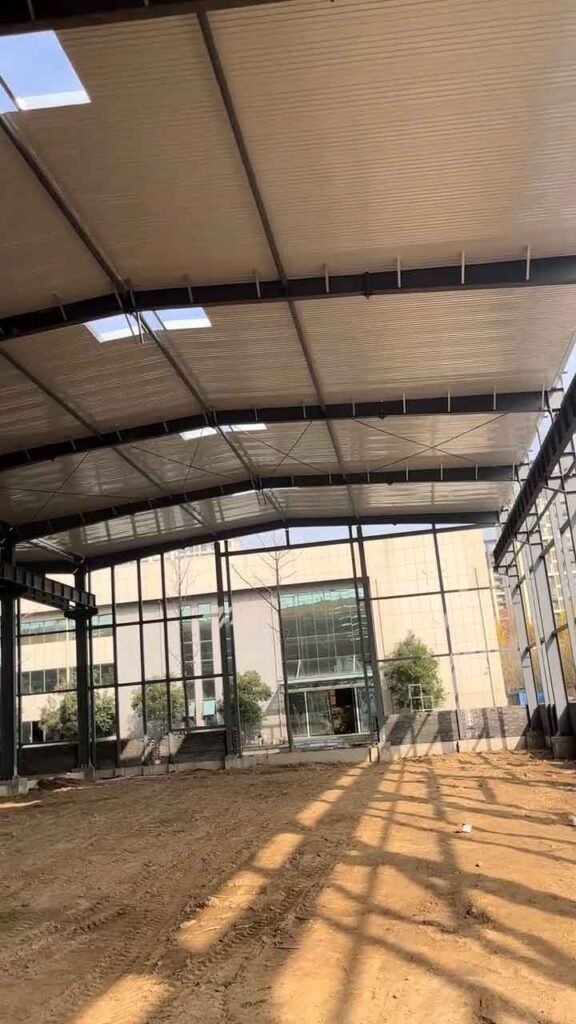 Interior de una bodega industrial prefabricada con estructura de vigas de acero y láminas de techo con tragaluces