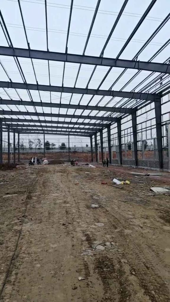 Interior despejado de una bodega metálica industrial con estructura de pórticos de gran luz