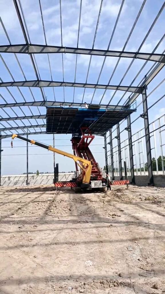 Plataforma de elevación tipo tijera trabajando en la techumbre de una nave para determinar el costo estructura metálica según montaje.