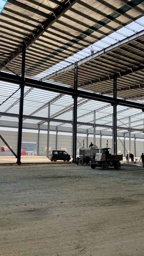 Perspectiva técnica de un edificio industrial de acero con columnas de carga pesada y marcos de gran altura.