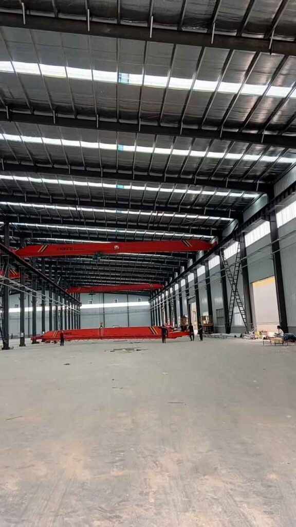 Amplio espacio interior de un almacén metálico fabricado por una empresa de acero estructural con iluminación natural.