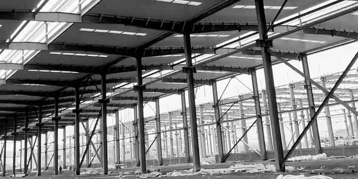 Vista interior de una estructura metálica industrial de gran envergadura con pórticos rígidos y diseño de ingeniería avanzada.