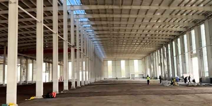 Panorámica interior de una estructura metálica prefabricada blanca lista para la instalación de servicios industriales.