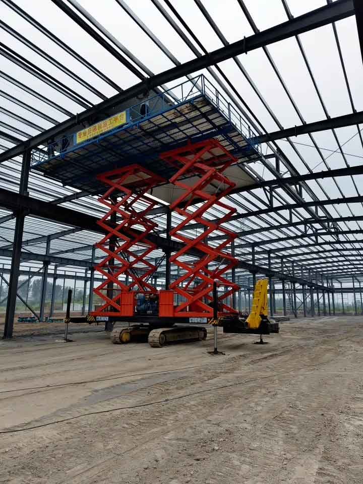 Detalle de una estructura prefabricada modular siendo instalada por operarios en una plataforma elevada azul en la parte superior.