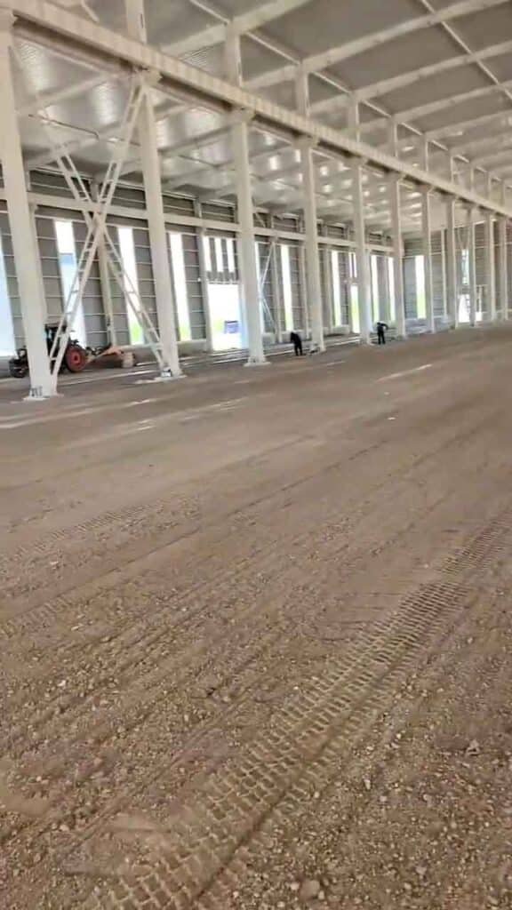 Montaje de galpón industrial prefabricado con alineación de columnas estructurales y cerramientos laterales metálicos.