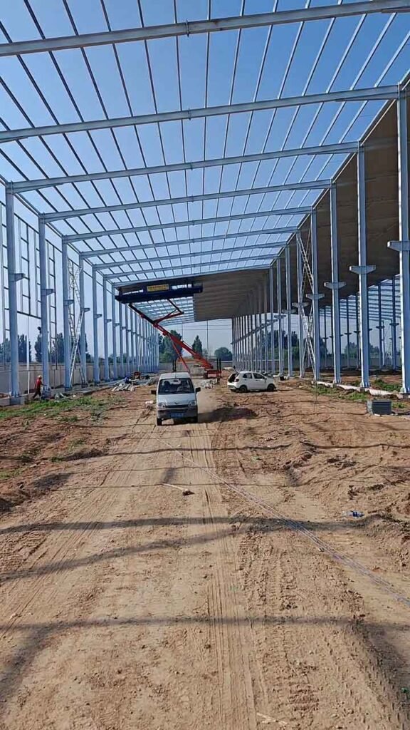 Interior de un galpón industrial prefabricado de gran envergadura mostrando el espacio diáfano y la estructura de techumbre.