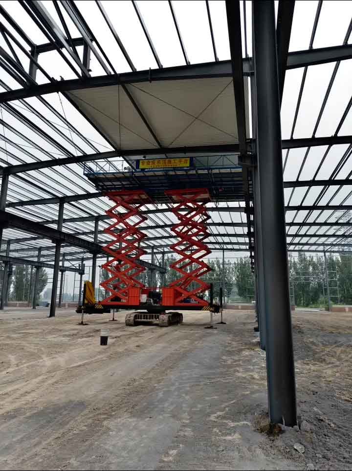 Montaje estructural de un galpón metálico con pilares de acero gris alineados y cerchas superiores listas para la cobertura.