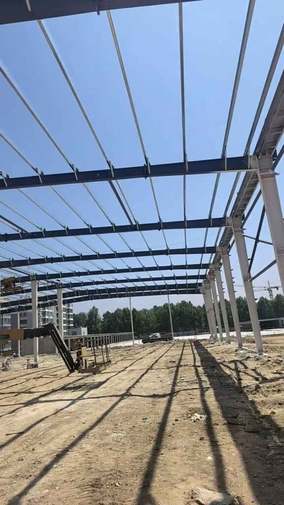 Estructura de techo de un galpón prefabricado con correas de acero instaladas bajo un cielo despejado.