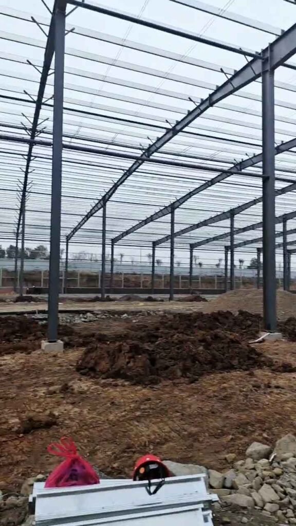 Componentes de galpones importados de China en etapa de ensamblaje final en sitio de obra