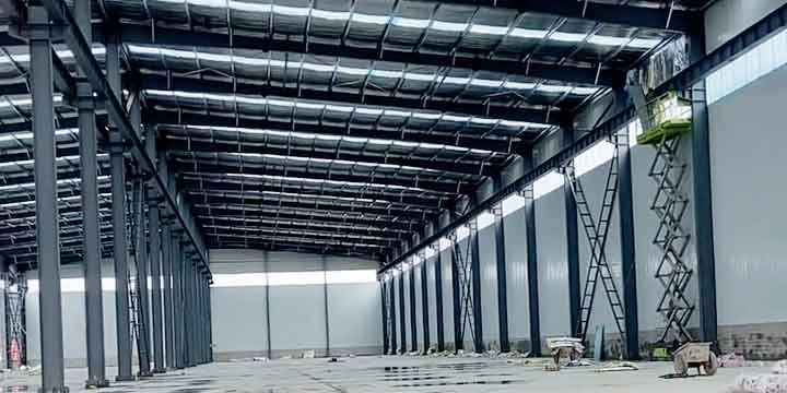 Uso de plataforma de elevación scissor lift en la obra de un industrial warehouse supplier especializado en montajes de altura.