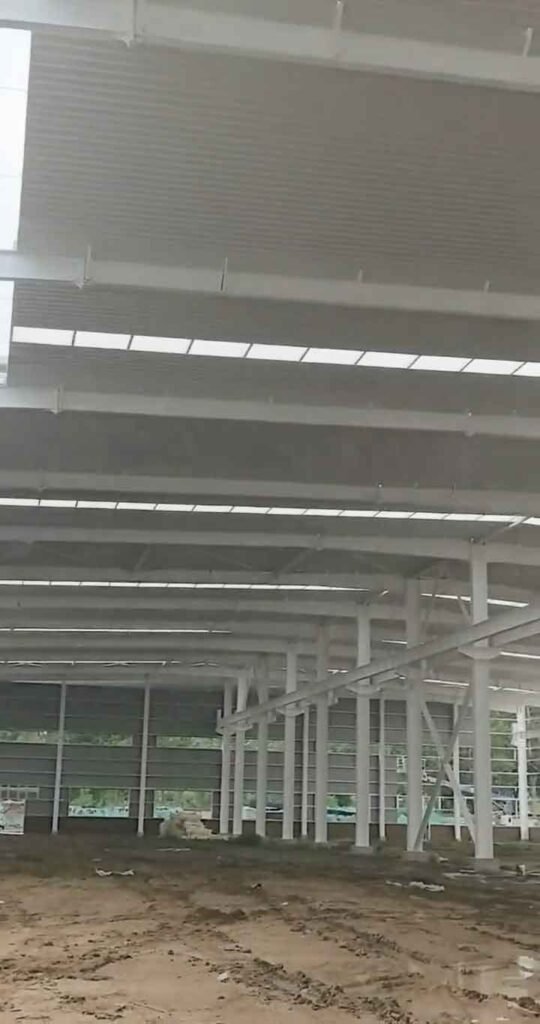 Detalle de la techumbre de una planta de estructuras de acero con paneles aislantes y franjas de iluminación natural.
