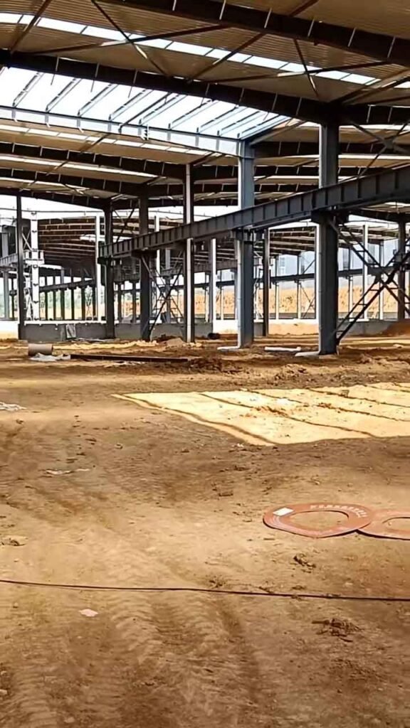Estructura interior de acero negro en fase de obra sobre terreno de tierra, ideal para cotizar el precio galpón metálico.