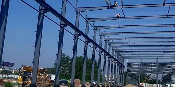 Operación de montaje de techumbre por un prefab warehouse supplier global con maquinaria pesada en sitio.