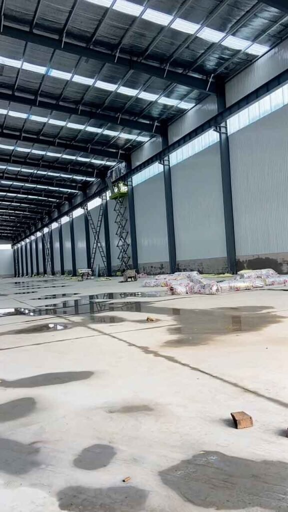 Interior de una nave logística masiva en proceso de construcción por un prefab warehouse supplier líder.