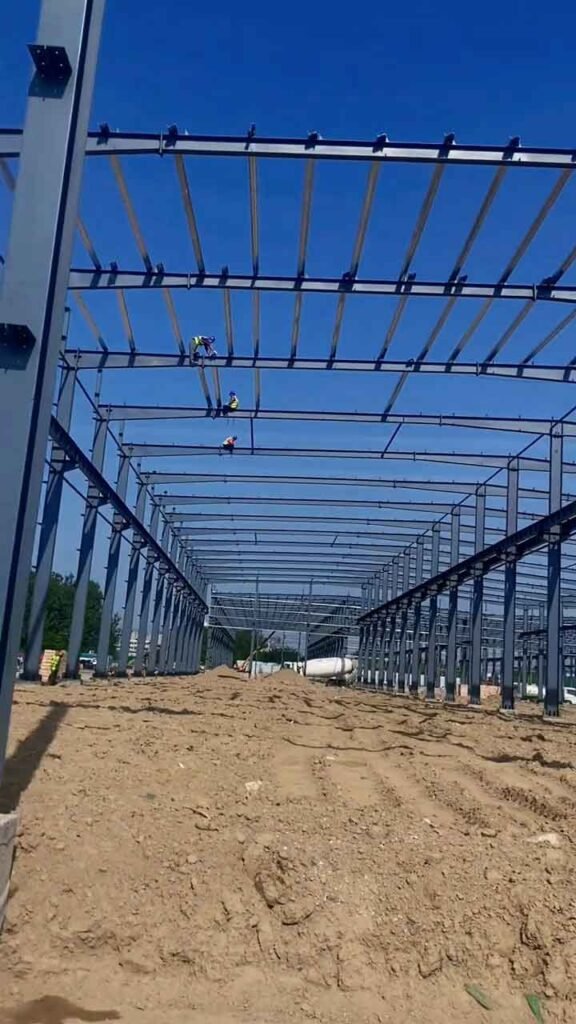 Perspectiva profunda de una nave industrial multicrujía construida por un proveedor de almacenes metálicos prefabricados.