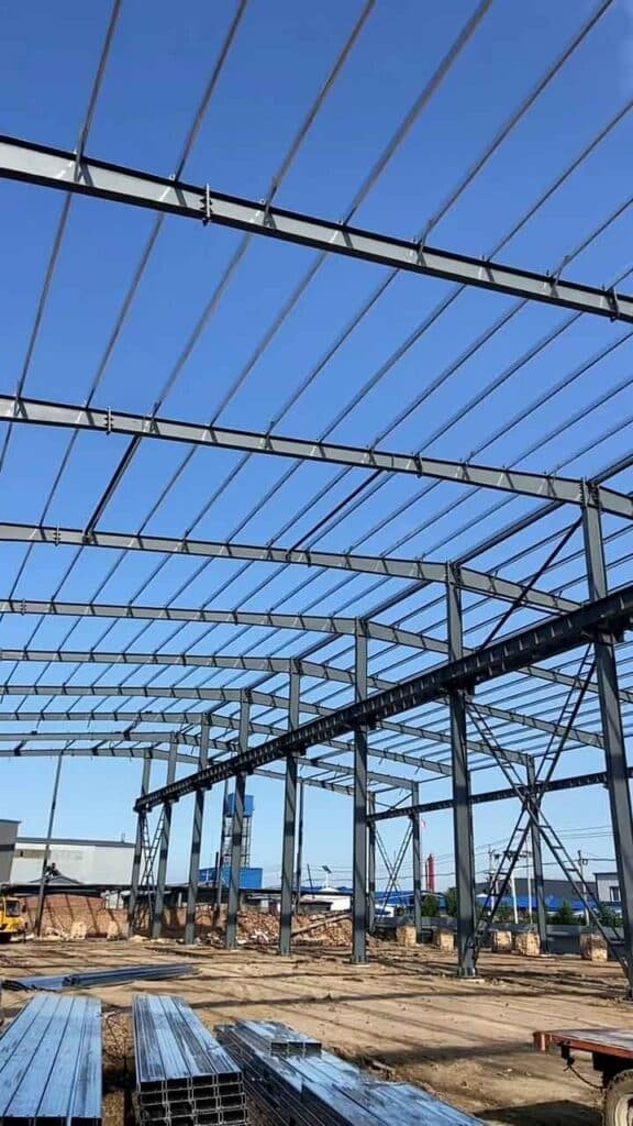 Montaje de estructura principal con grúa amarilla por un proveedor de bodegas de acero especializado en naves logísticas.